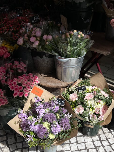 A display of fresh flower bouquets at Charlton Flowers, a flower shop in Woolwich Road. The arrangements include purple and white flowers, pink roses, and delicate light purple blossoms, all wrapped i