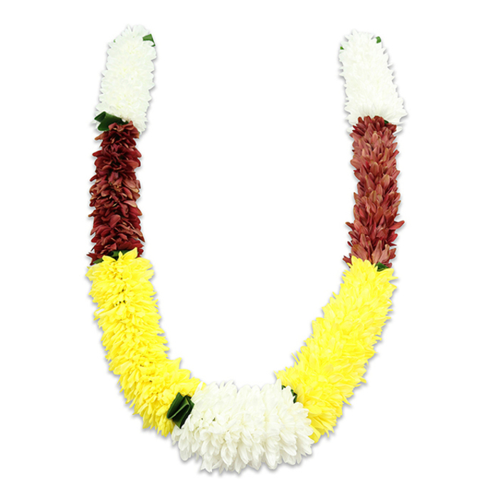 Against a stark white background a lovingly crafted U-shaped mala is photographed in quiet detail, its slight shadow revealing the volume and precision of the work. The garland's two symmetrical arms begin with compact cylinders of creamy-white, chrysanthemum-like fabric blooms, each composed of many tiny layered petals that give a plush, gently feathery finish. Directly beneath those white caps sit dense bands of deep maroon or reddish-brown flowers, their tightly packed petals offering a rich, earthy counterpoint. Flowing from the maroon is the garland's longest, most pronounced section: bright, cheerful yellow blossoms arranged to form the broad curve of the U, their abundant, pom-pom appearance evoking marigolds used in traditional ceremonies. At the lowest point of the curve, where the yellow arcs converge, a generous cluster of pure white blooms becomes a radiant centrepiece, slightly more open and luminous than the upper whites. Small dark-green leaf-like accents are discreetly placed at several transitions - most notably between yellow and white - giving the palette a natural punctuation. The materials are clearly synthetic fabric; thousands of individual petals are layered with exacting care to mimic real flowers while offering durability for repeated use in Hindu pooja, temple offerings, weddings, Diwali or Holi celebrations. As a local floral artisan in Charlton might note, this mala reads as both an offering and a memory: visually rich, formally balanced, and made to drape gracefully over statues, doorways, or ceremonial frames in nearby Woolwich or Greenwich.