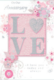 This anniversary card design is captured as though it has just been laid on a tidy table in a Charlton home, ready to accompany a fresh bouquet of blooms. At the heart of the card, the word LOVE stands in raised, glitter-touched letters, the soft blush pink colour glowing against a delicate pastel background. The embossed lettering gives a clear sense of dimension, so you can almost feel the gentle rise under your fingertips, while the fine glitter adds a light dusting of silver sparkle along the tops of each letter. Surrounding this central word, an airy spray of stylised flowers, tender buds, and curling leaves stretches across the surface like a loosely gathered floral garland. The flowers are illustrated with refined, flowing lines and gentle shading, in tones of blush pink, pearlescent white, lavender-tinted lilac, and cool grey. Their overlapping shapes create layers of interest, as if different stems and blossoms were arranged together by a skilled florist. Soft tendrils and swirling stems link the flowers, guiding the eye around the card in a circular rhythm. Nestled among the petals are tiny details-subtle butterflies, petal-like accents, and touches of silver foil-that bring a playful hint of movement, like a spring breeze around Charlton's gardens. The background is a smooth, velvety blush that softly frames the design without distraction. At the bottom and slightly off to one side, the words On Our Anniversary and I love you today and always are written in an elegant, understated script, sitting gently within the floral composition. The overall effect is one of quiet celebration, tenderness, and enduring connection-a paper keepsake that feels as thoughtful and personal as an expertly arranged anniversary bouquet.